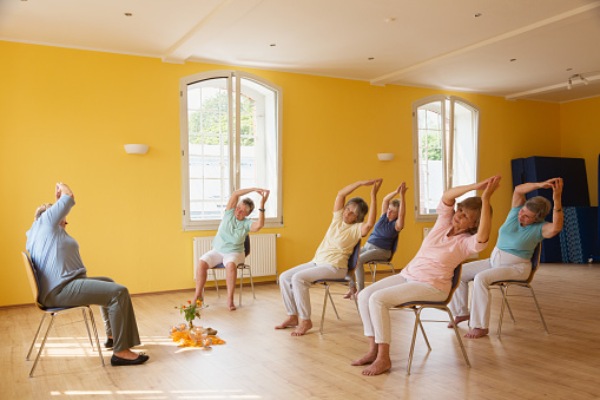 Chair yoga class in senior living center in St. Petersburg, Florida.