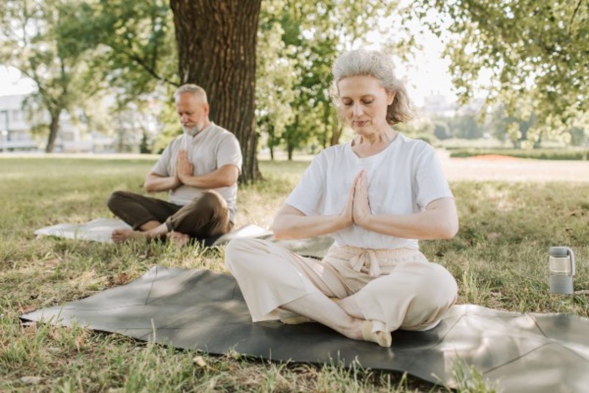 Elderly man and woman practicing yoga outdoors in St. Petersburg, Florida